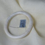 Authentic natural jade bangle in light white tone with delicate stone veins, polished finish, close-up product photo