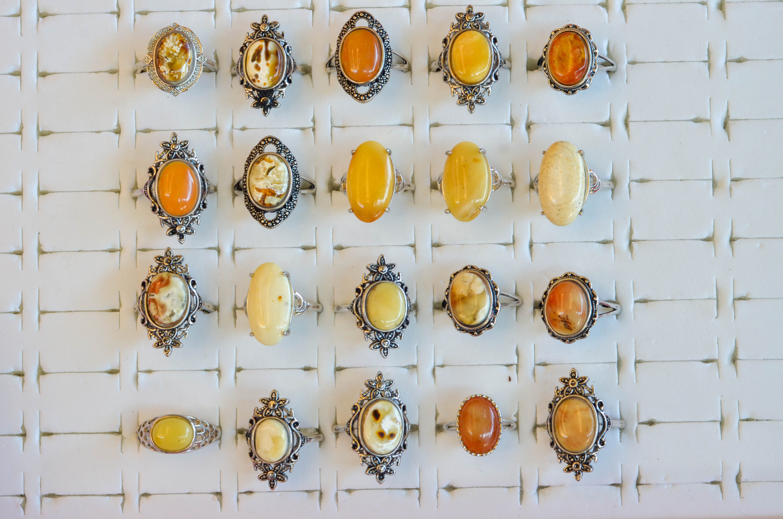 Natural amber ring with an open back, silver-plated vintage style sitting in a holder