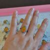 Natural amber ring with an open back, tried on hand
